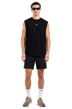 Man wearing a black sleeveless shirt and shorts on a white background