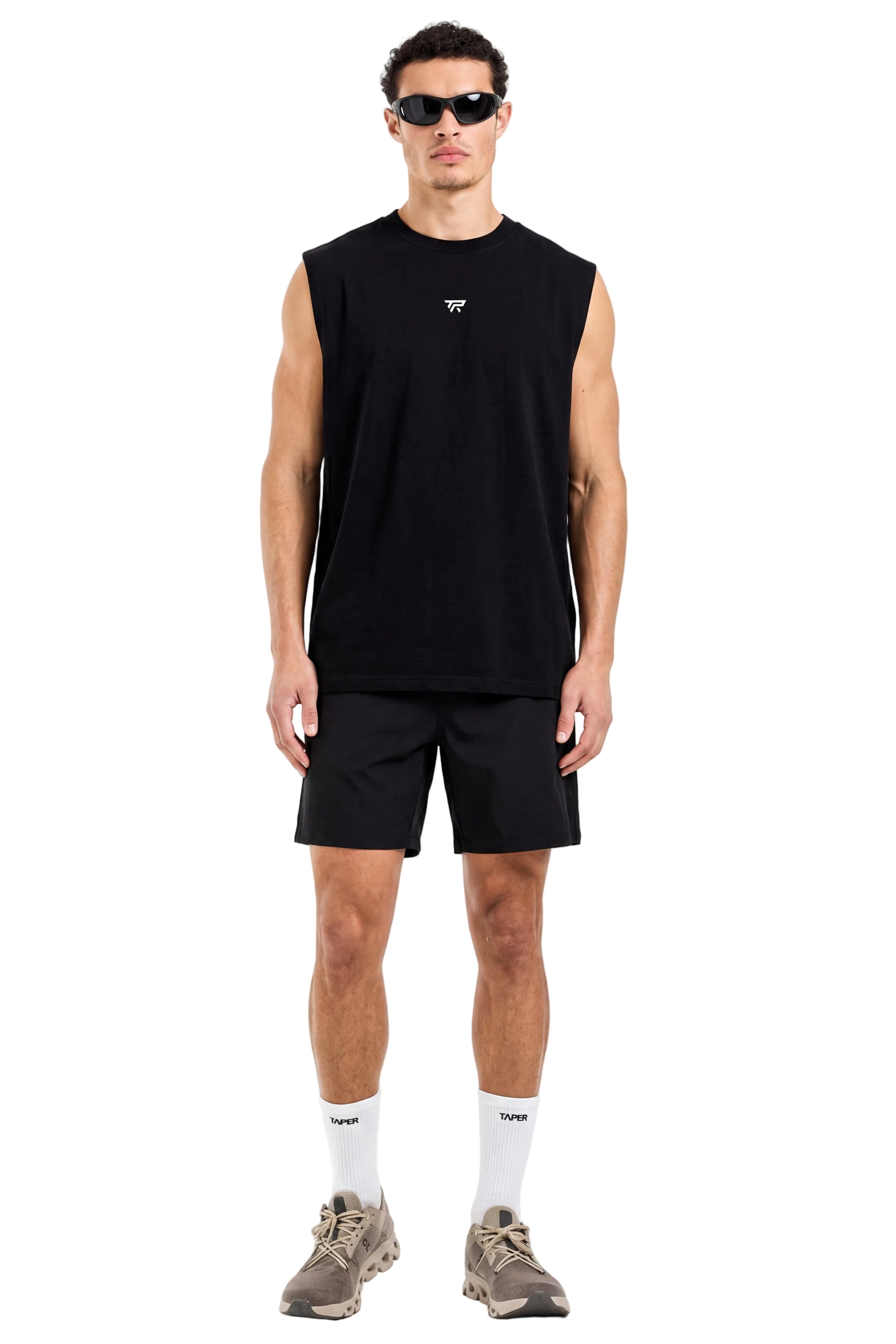 Man wearing a black sleeveless shirt and shorts on a white background